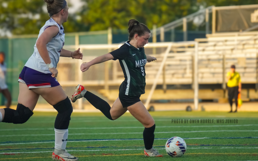 Side view of Mason girl preparing to kick ball