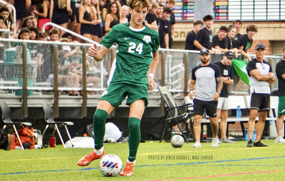 Boys soccer player kicking soccer ball