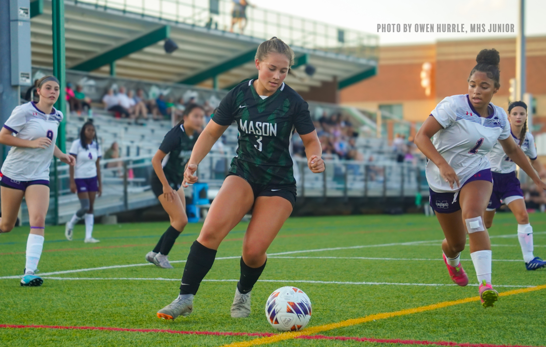 girl about to kick soccer ball