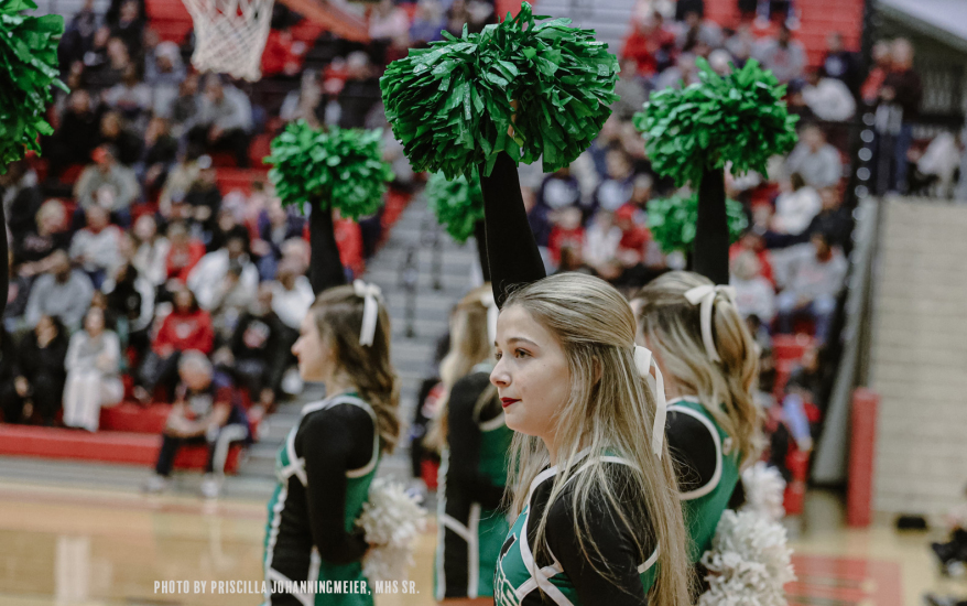 girls holding up one pom-pom in right hand